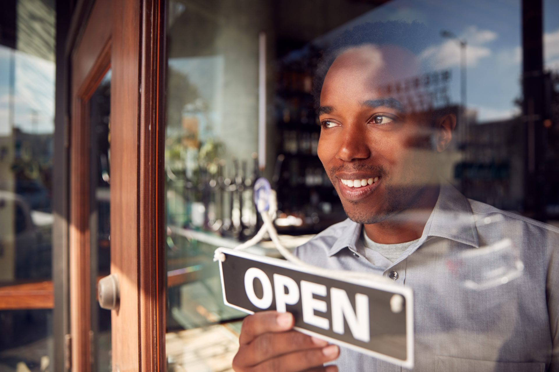 Restaurant owner turning the open sign on the door