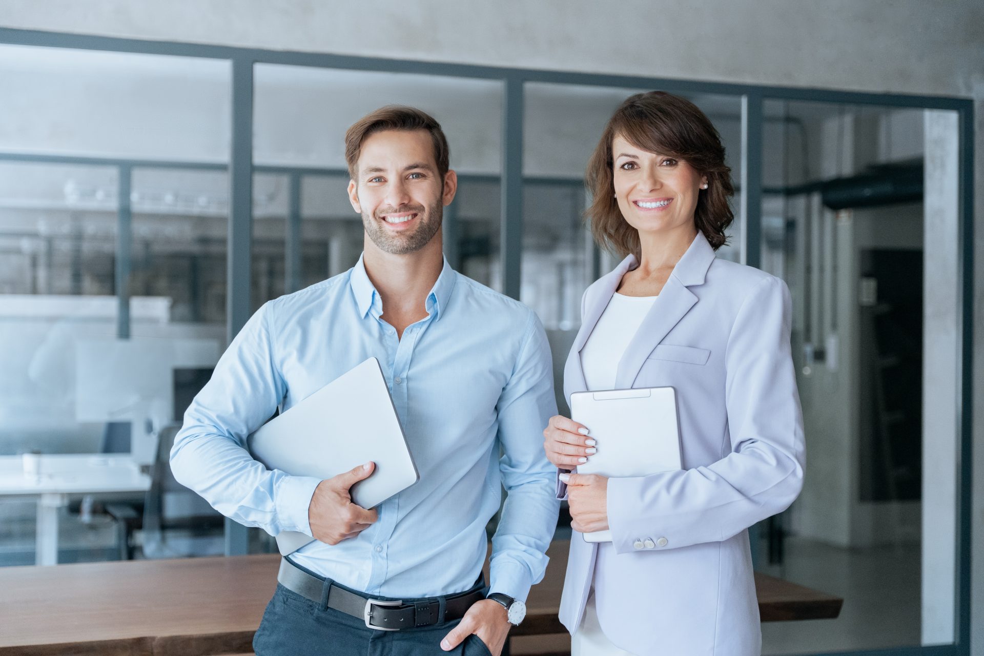 Two confident business leaders standing in office